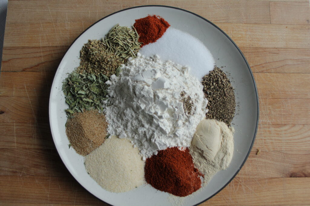 Ingredients for homemade beef stew seasoning mix on a white plate
