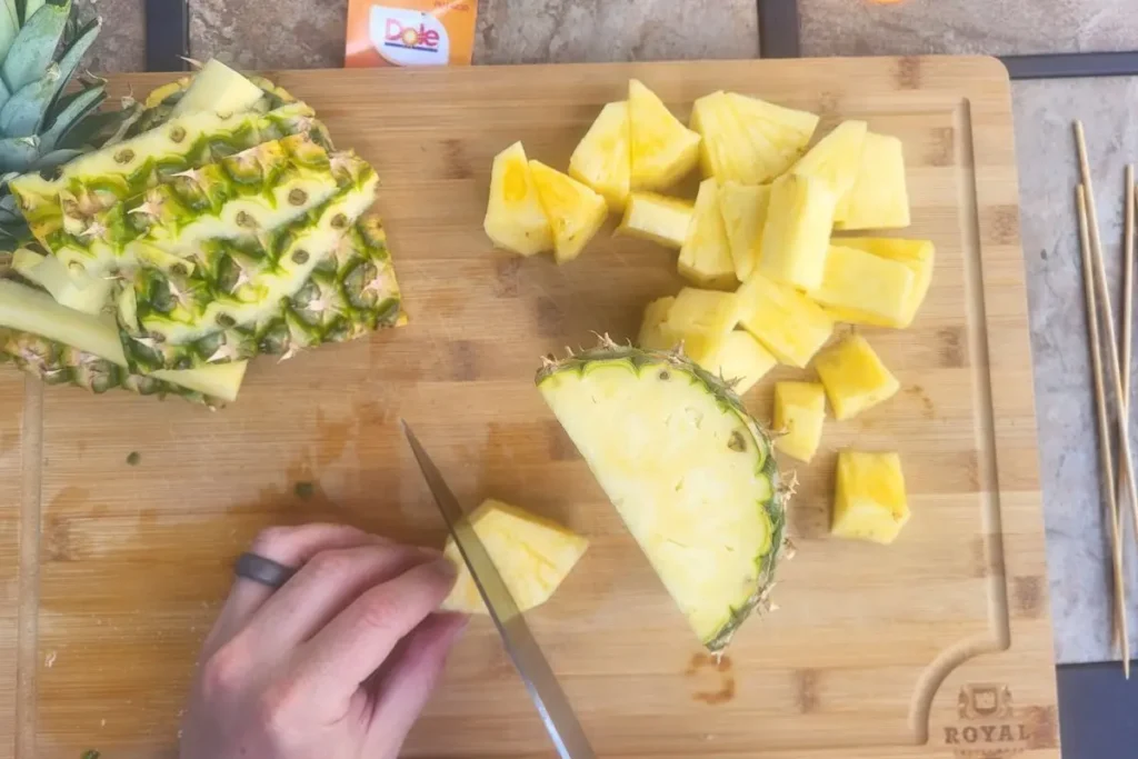 cutting pineapple for grilled steak and shrimp kabob